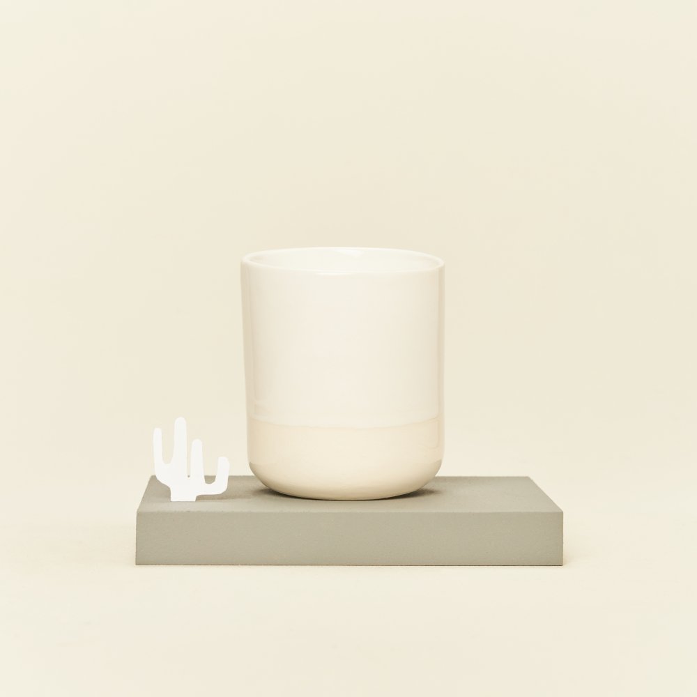 Ceramiczny kubek bez uszka w kolorze złamanej bieli.